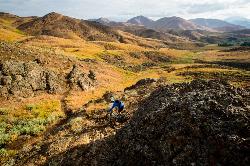 Mountain biker passing dark rock outcrops at Croy Creek. IMBA / Leslie Kehmeier via BLM, public doma courtesy of BLMIdaho&nearr; (Public domain&nearr;)