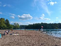 The sand crescent at the north end of Green Lake, with the lifeguard stand and swim floats out courtesy of PotatoCow25&nearr; (CC BY-SA 4.0&nearr;)