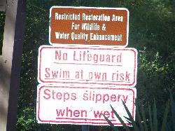 Posted sign: no lifeguard, swim at your own risk, steps slippery when wet courtesy of Paul Clark&nearr; (CC BY 2.0&nearr;)