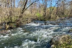 The Musconetcong River running out of the lake below the dam at the edge of the park courtesy of Zeete&nearr; (CC BY-SA 4.0&nearr;)