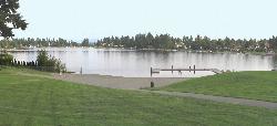 Panorama across the beach and the floating dock toward the far shore of Angle Lake courtesy of Gr8white&nearr; (Public domain&nearr;)