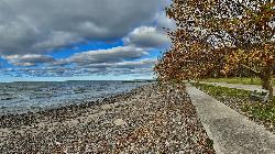 East along the shoreline, where the sand gives way to cobble beside the paved lakefront walk. courtesy of Andre Carrotflower&nearr; (CC BY-SA 4.0&nearr;)