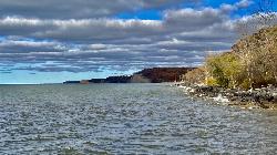 The wooded shoreline bluffs northeast of the swim beaches, with their pale cut faces above the rocky courtesy of Andre Carrotflower&nearr; (CC BY-SA 4.0&nearr;)