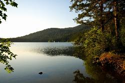 A small sailboat on Cascade Lake below the forested hills of Moran State Park courtesy of stevevoght&nearr; (CC BY-SA 2.0&nearr;)