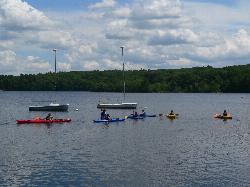 Kayaks and small sailboats pulled up on the reservoir shore courtesy of NewtonCourt&nearr; (CC BY-SA 4.0&nearr;)