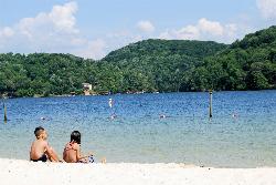 The shallow edge of the swim area, buoys offshore and forested hills along the far side of the lake courtesy of Virginia State Parks staff&nearr; (CC BY 2.0&nearr;)