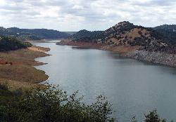 A side arm of Don Pedro Reservoir on the Tuolumne River, with the drawdown ring exposed above the wa courtesy of docentjoyce&nearr; (CC BY 2.0&nearr;)