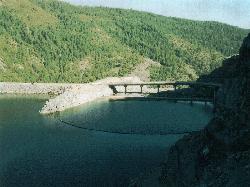 Log boom and concrete structure at the west end of the reservoir near Lower Hell Hole Dam, July 2005 courtesy of Marcia Wright&nearr; (Public domain&nearr;)