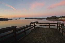 The park fishing pier at dawn, with the beach visible along the far shoreline. courtesy of Virginia State Parks staff&nearr; (CC BY 2.0&nearr;)