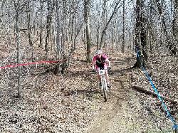 A racer on singletrack through bare April woods on the Hop Brook Lake trail system courtesy of k.steudel&nearr; (CC BY 2.0&nearr;)