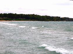 The sand shoreline north of the harbor seen from the water, with the wooded bluff behind courtesy of Ken Lund from Reno, Nevada, USA&nearr; (CC BY-SA 2.0&nearr;)