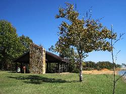 Stone picnic shelter on the grass above Enid Lake courtesy of Thomas R Machnitzki (thomas@machnitzki.com)&nearr; (CC BY 3.0&nearr;)