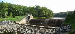 Tea colored water sheeting over the crest of the dam below the lake courtesy of User:Ruhrfisch&nearr; (CC BY-SA 4.0&nearr;)