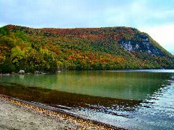 Mount Hor across the water from a sandy stretch of Lake Willoughby shoreline courtesy of From the nek&nearr; (CC BY-SA 3.0&nearr;)