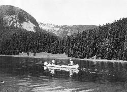 Canoeists on Crystal Lake below the forested slopes of the Big Snowy Mountains (historic Forest Serv courtesy of Forest Service Northern Region from Missoula, MT, USA&nearr; (Public domain&nearr;)
