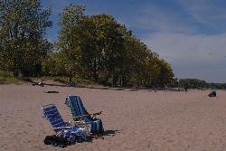 Beach chairs on the sand at Gillson Park beneath the shoreline trees. courtesy of Anovieten&nearr; (CC BY-SA 4.0&nearr;)
