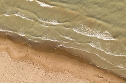 Lake Michigan waves washing onto the sand at Gillson Beach, seen from above. courtesy of Paul R. Burley&nearr; (CC BY-SA 4.0&nearr;)