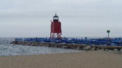 The beach at Michigan Beach Park on an overcast July day, looking out to the pier walkway and lighth courtesy of Notorious4life (talk) (Uploads)&nearr; (CC0&nearr;)