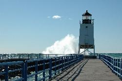 The railed walkway out the south pier to the light, with spray from waves on the lake side. courtesy of abarndweller&nearr; (CC BY 2.0&nearr;)
