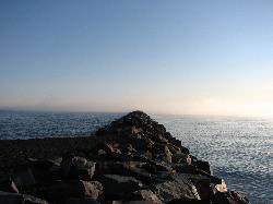 Armor stone of the west breakwater, with the beach on the left and Lake Superior beyond. courtesy of Chuck Ritola&nearr; (CC BY-SA 3.0&nearr;)