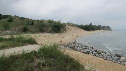 Beach and dune bluff west of the breakwater, with waves rolling in from Lake Michigan. courtesy of Chris Light&nearr; (CC BY-SA 4.0&nearr;)