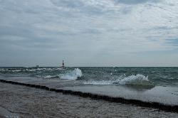 Waves rolling onto the south end of the beach, with the Waukegan Harbor breakwater light offshore. courtesy of Joseph Gage&nearr; (CC BY-SA 2.0&nearr;)