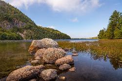 Clear water and granite boulders along the shore at Echo Lake Beach, with Beech Mountain's cliffs on courtesy of Christian Collins&nearr; (CC BY-SA 2.0&nearr;)