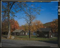 Park cabins in fall color with Lake Taghkanic showing through the trees behind them. courtesy of Haas, David W., creator&nearr; (Public domain&nearr;)