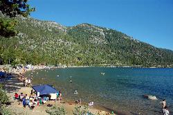 The curve of the Main Beach shoreline with swimmers and paddlers in the shallows. courtesy of DimiTalen&nearr; (CC BY-SA 3.0&nearr;)
