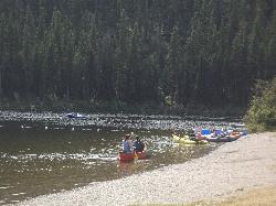 Canoes and rafts pulled up on the day-use beach, with the swim buoys strung across the water. courtesy of Forest Service Northern Region from Missoula, MT, USA&nearr; (Public domain&nearr;)