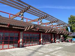 The Enatai boathouse with its red roll-up doors on the waterfront. courtesy of Steven Pavlov&nearr; (CC BY-SA 4.0&nearr;)