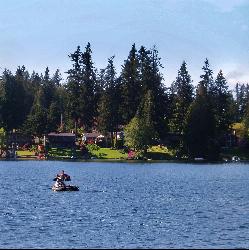 A person on an inflatable float out on Pine Lake, with the wooded shoreline behind. courtesy of KurtClark&nearr; (CC BY 2.0&nearr;)