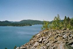Sheridan Lake seen from a rocky point, with pine-covered hills around the water. courtesy of Rolf Blauert Dk4hb&nearr; (Public domain&nearr;)