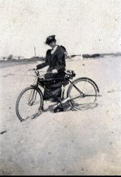 Vintage postcard of a visitor with a bicycle at Walnut Beach, looking east toward the harbor docks. courtesy of Ashtabula Archive&nearr; (Public domain&nearr;)