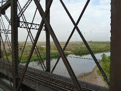 The Colorado River upstream of the park, seen through the bridge trusses at the Yuma Crossing, with  courtesy of Chris English&nearr; (CC BY-SA 3.0&nearr;)