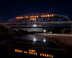 The sandy river beach at Gateway Park at night, under the lit Ocean-to-Ocean Highway sign. courtesy of Bureau of Reclamation&nearr; (CC BY-SA 2.0&nearr;)