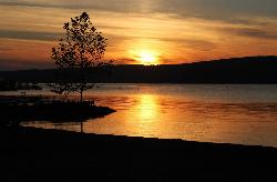 The beach shoreline at Champlin Beach with the sun low over the hills above Keuka Lake. courtesy of See1,Do1,Teach1&nearr; (CC BY 2.0&nearr;)