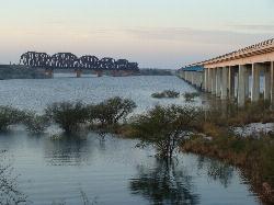 Amistad Reservoir at dusk beside the US 90 highway bridge and the railroad truss bridge next to Gove courtesy of Zereshk&nearr; (CC BY-SA 3.0&nearr;)